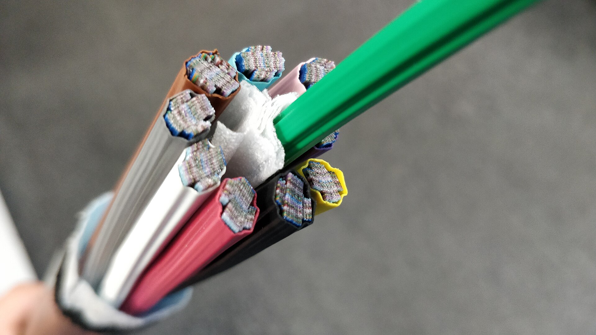 A ribbon fibre optic cable cut open, showing colour-coded tubes each packed with stacked ribbons of fibres